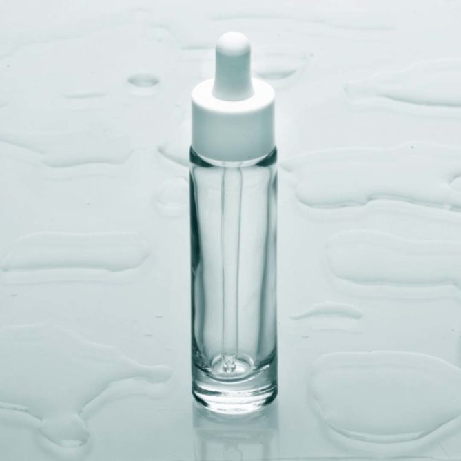 Un flacon cosmétique fin en verre transparent avec un compte-gouttes blanc